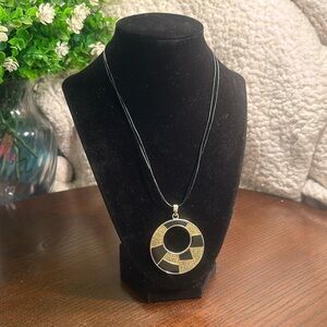Black and gold-tone, silver-tone back circular pendant on double black cord